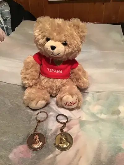 This adorable, gently loved teddy bear stands approximately 9 inches tall, and the two keychains are...