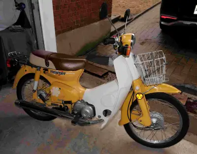 Moto Honda Passport C70 1982 jaune toute originale en excellent état. Elle fonctionne à l'essence av...