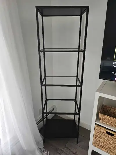 This black metal and glass shelving unit is perfect for adding a modern touch to any room, offering...