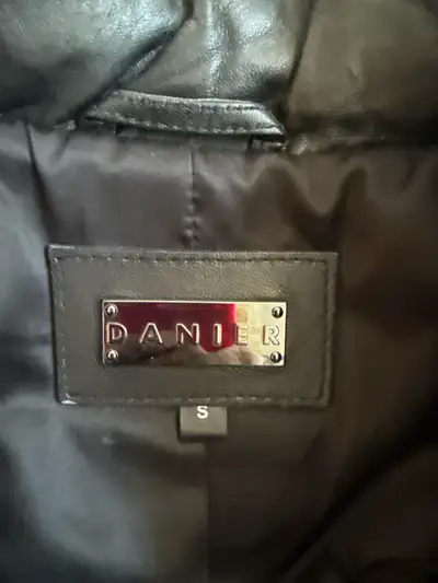 This is a Danier black leather jacket with real fur around the hood, in a size small. The coat is li...
