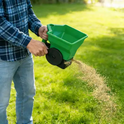 Hand held fertilizer spreader with shoulder strap for large lawns/yards