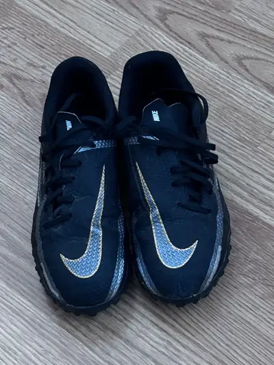 Black and gold Nike Phantom GT4 turf football shoes . Lace-up closure. Youth size 4.5. If it’s liste...