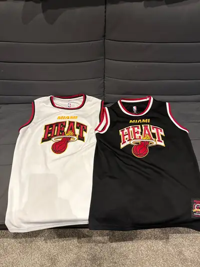 I'm selling two used Miami Heat jerseys, perfect for any young basketball fan! One is black, size 14...