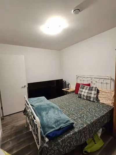 This den room features a cozy setting with a comfortable bed, side table, and ample space for a sing...