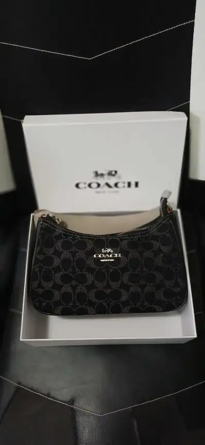 This charming, nearly new Coach baguette bag features the signature Coach print. It comes with a det...