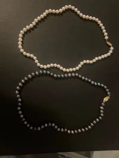 Enhance your collection with this set of two pearl necklaces, one in classic white and the other in...
