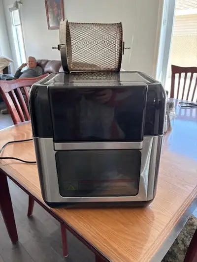 Friteuse à air chaud avec une panier rond qui tourne et 2 grilles pour le rôtissage et un plateau po...