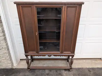 Vintage solid wood and real wood veneer with one centered glass door. Good, clean condition with som...