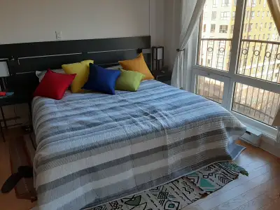 Ikea King Size bed, black, wood. Includes headpiece, matelas, new (unused) bedsheets and covers.