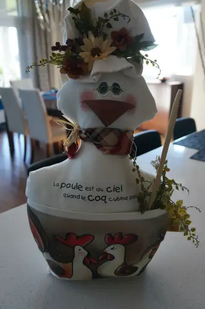 Poule décorative en tissu beige. et inscription « La poule est au ciel quand le coq cuisine ». Cuill...