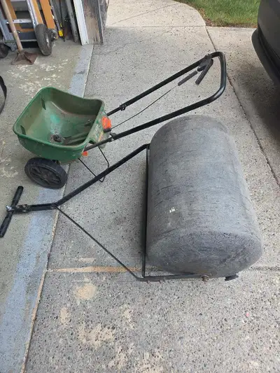 Large Scott's wheeled Fertilizer Spreader and a water fill sod Roller. Plastic drum with a metal han...