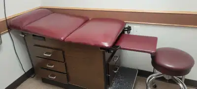 This pre-owned medical examination table and accompanying chairs provide a functional setup for a cl...