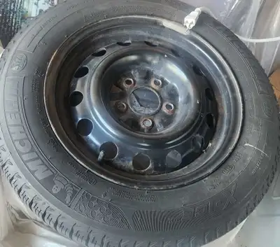This pre-owned Michelin X-Ice winter tire, size 195/65R15, is mounted on a steel rim and ready for y...