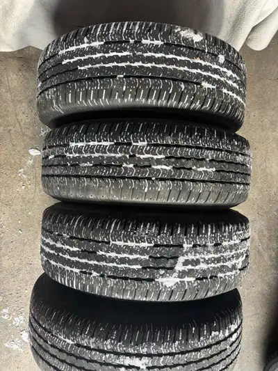 These Goodyear Wrangler ST tires, size P265/70R17, are pre-owned and show signs of wear consistent w...