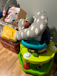 A lot of baby stuff clothes, toys, bassinet