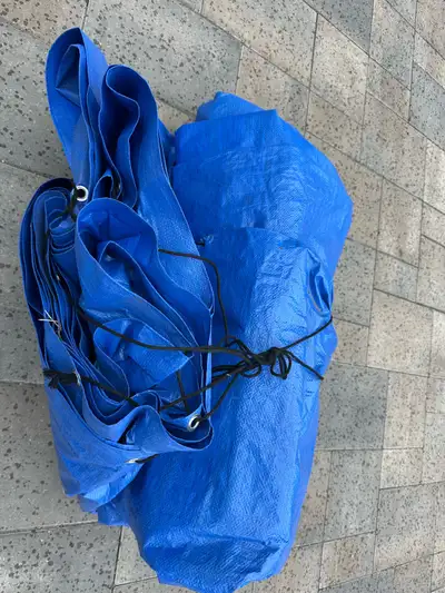 This is a used blue tarp, perfect for covering items during outdoor projects or protecting equipment...