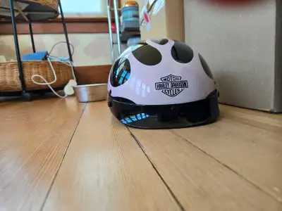 This is a Harley-Davidson motorcycle helmet in a stylish pink colour with black accents, designed to...