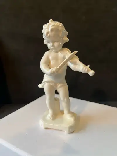 This charming, used porcelain figurine features an angel playing the violin, adding a touch of seren...