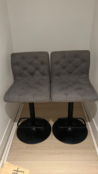 2 grey fabric stool chairs with black base 