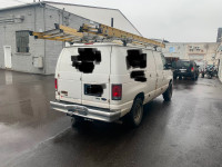2012 Ford E250 Cargo van with shelves and ladder rack.