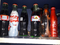 Lot d'items Coca-Cola, incluant bouteilles de collection pleine.