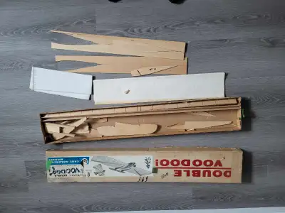A model airplane kit. Pieces of wood in a box. It has a schematic of the finished product on the box...