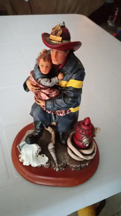 Beautifully detailed firefighter carrying a small child. In excellent condition, from 1997. Cash onl...