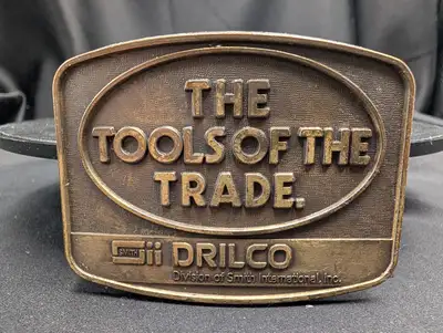 This vintage brass belt buckle features the distinctive Drilco logo, a division of Smith Internation...