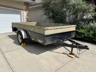 Tilt deck utility trailer with 7’ x 12’ pressure-treated deck and 2’ side walls. Manufactured by H&H...