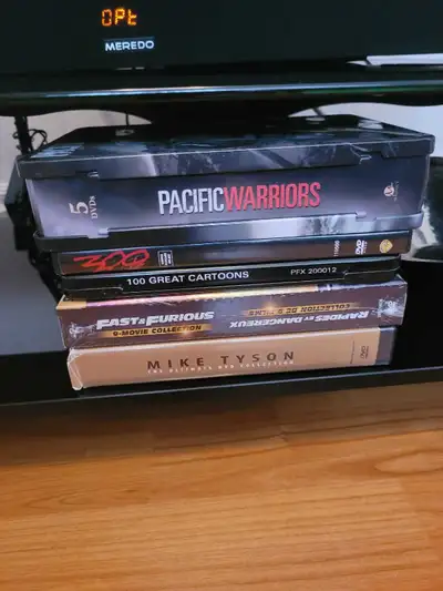 For sale is a collection of used DVDs featuring titles such as Pacific Warriors, 300, 100 Great Cart...