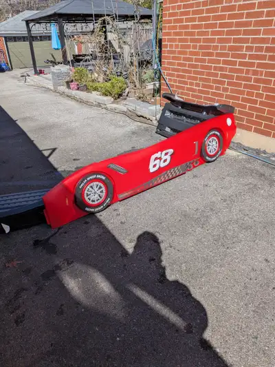 At the curb. Red plastic frame for kids Car Bed in good condition but some decals have come away. It...