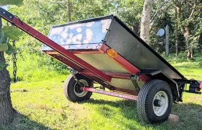 Compact and sturdy utility trailer features a durable steel frame and a reliable wood floor, perfect...