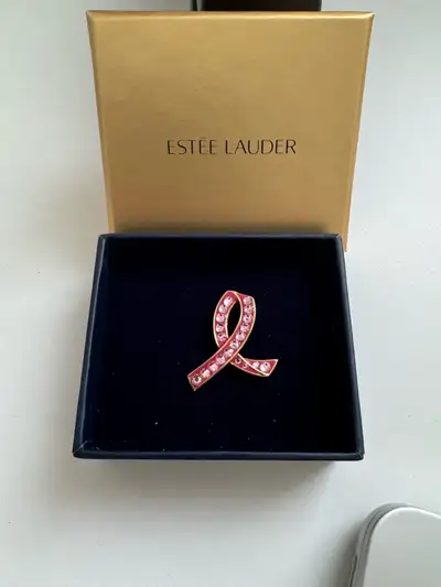 This Estee Lauder ribbon pin is a beautiful way to show your support for breast cancer awareness. Th...