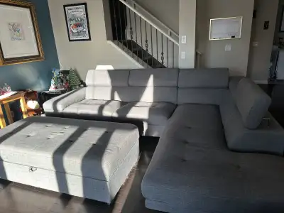 Comfortable gray sectional sofa with chaise and storage. Has metal legs and gray fabric upholstery....