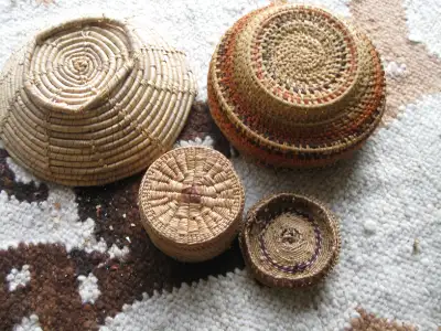 A collection of Native Indian baskets and one glass container. Open to reasonable offers.