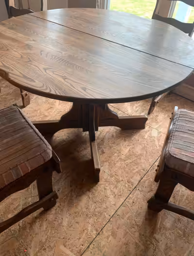 This round oak dining table comes with four chairs and is perfect for a smaller dining space, featur...