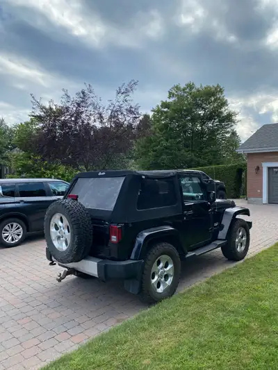 À vendre, Jeep Wrangler Sahara 2015 noir, avec moteur V6 3.6L et transmission manuelle. Le Jeep est...