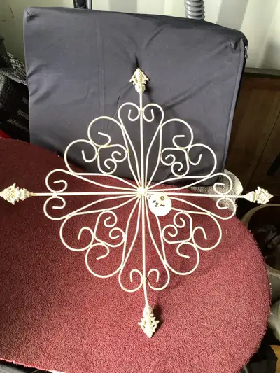 Beige metal decoration with arms that go 22” out to the 4 points. Would look great on a brick wall o...