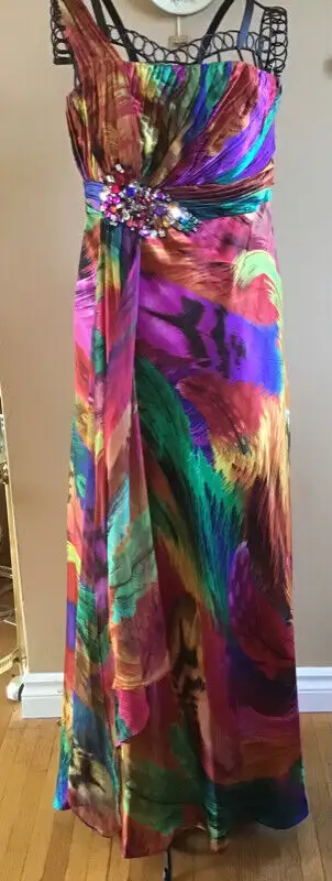 Get ready for prom and graduation season with this colourful sleeveless full length gown with peacoc...