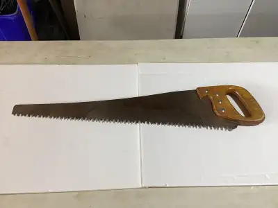 This vintage hand saw features a sturdy wooden handle and shows signs of age and use, making it a gr...