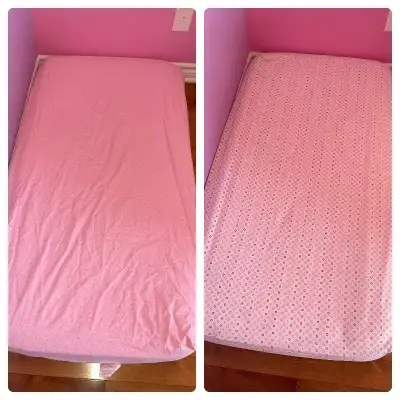 2 draps pour matelas de bassinette. Un est blanc avec des motifs ronds colorés. L’autre est rose ave...