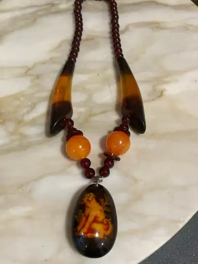 This amber necklace features striking amber pieces and unique design, making it a standout accessory...