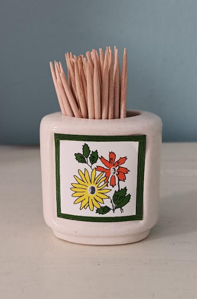 This sweet little off-white ceramic toothpick holder from the 60s is finished off with a yellow, ora...