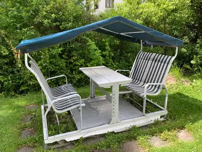 Balançoire Stella à 4 places, avec une table extensible au centre. En aluminium. Notes: Le plastique...