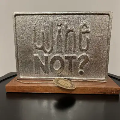 A stylish Home Bar decorative sign featuring the playful phrase “Wine Not?” in raised silver-tone me...