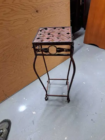 Add a touch of vintage charm to your home with this used wrought iron plant stand, featuring a woven...