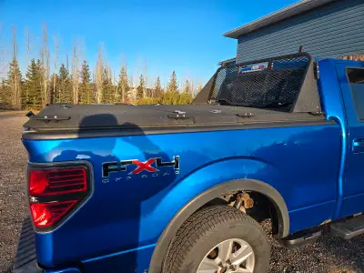 Diamondback truck bed cover with headache rack with light bar. Has two bins one on each side. Came o...