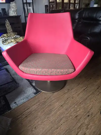 This vibrant red lounge chair is a statement piece, perfect for adding a pop of colour and modern fl...