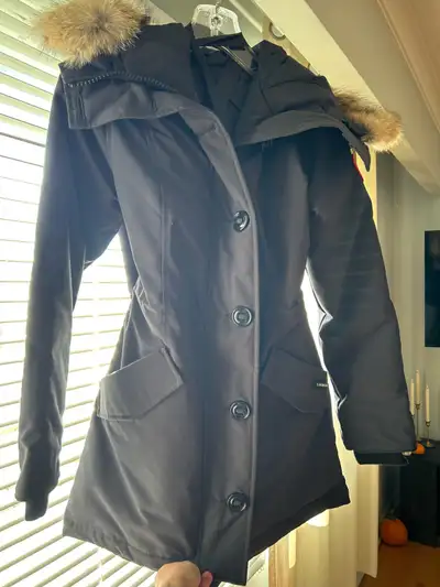 Brand new, never worn Women’s Canada Goose Parka. Size small. It’s a grey-ish navy blue. The picture...