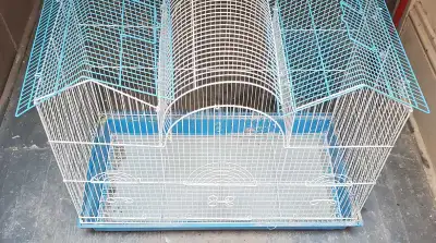 This is a used bird cage that's perfect for small birds like finches or canaries. It's designed with...